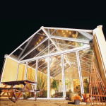 aluminium white conservatory roof lit up at night.